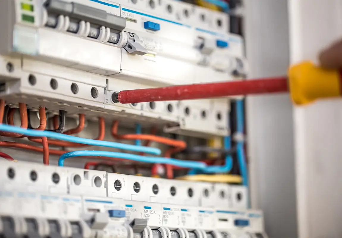 Électricien en train d'installer et câbler un tableau électrique par ADS Rénovation