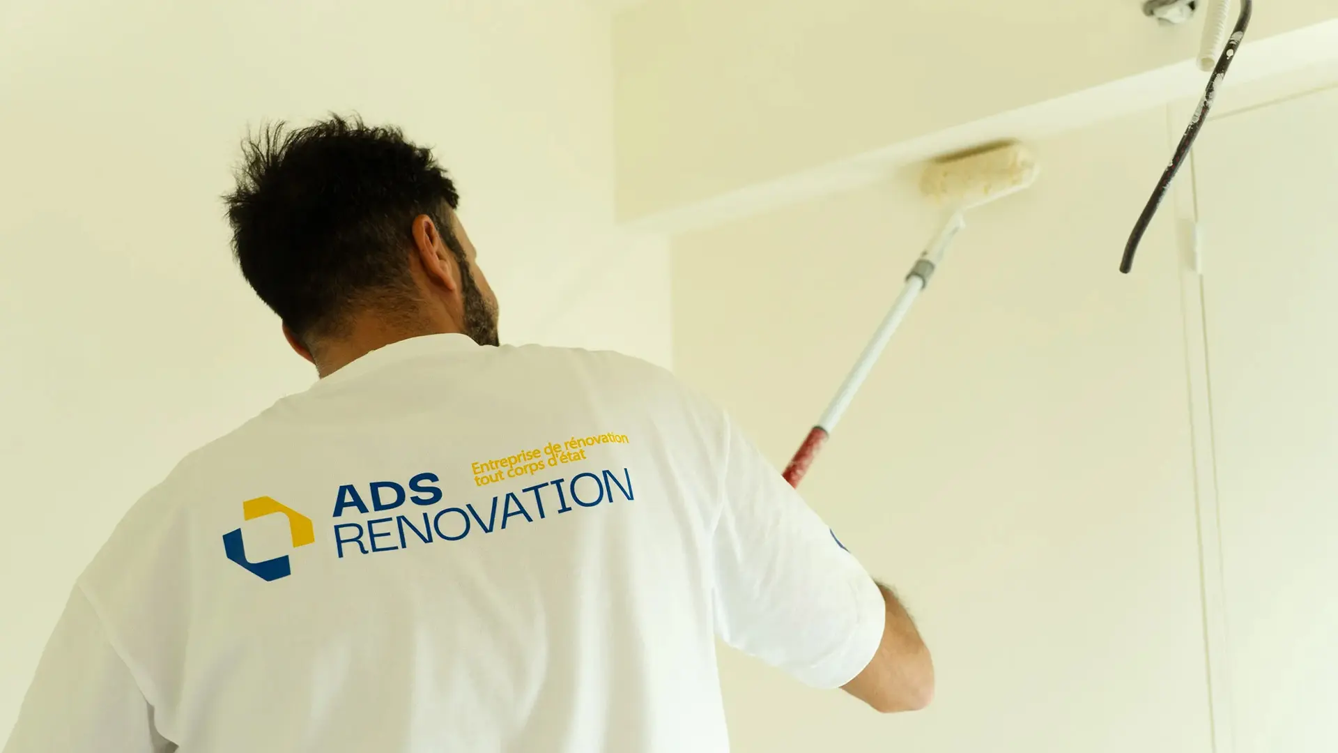 Peintre ADS Rénovation appliquant la peinture au rouleau sur un plafond – chantier de peinture intérieure à Cannes et Le Cannet